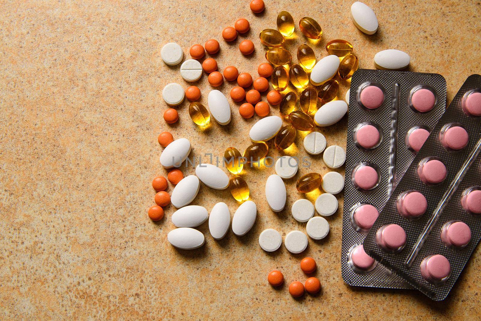 Blister with pink and orange pills, vitamin D and fish oil capsules  by ozornina