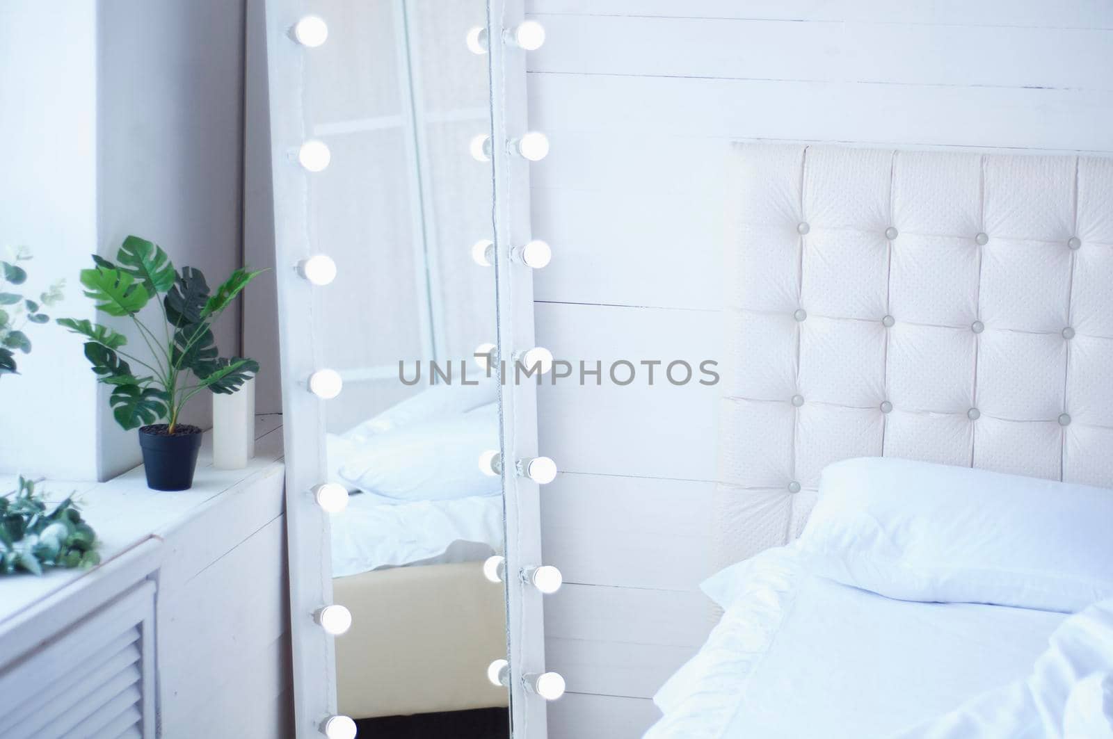 bouquet of flowers on the bed and a mirror with light bulbs