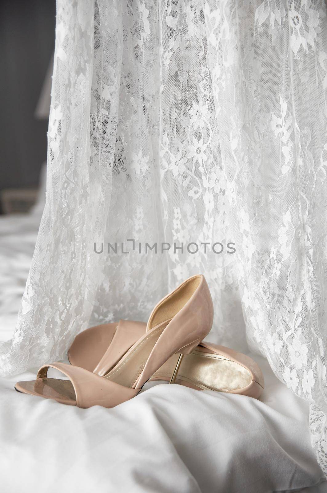 wedding shoes on the bed next to the dress