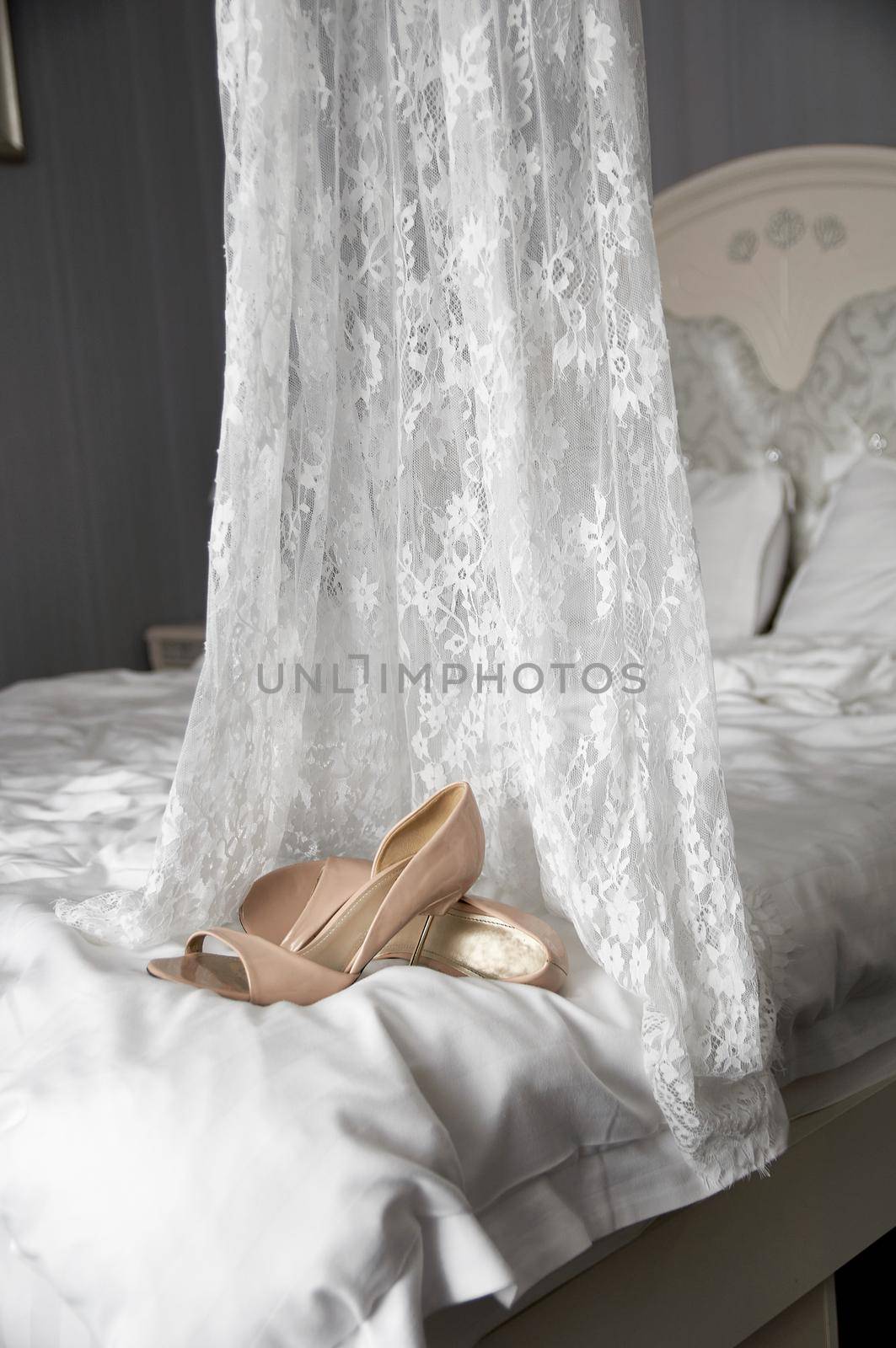 wedding shoes on the bed next to the dress