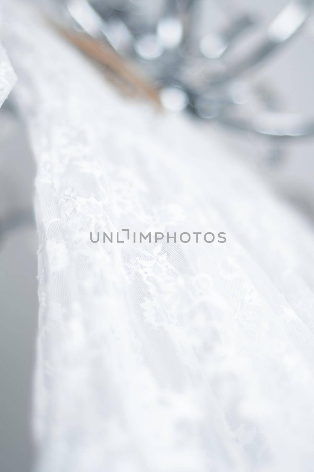 wedding peignoir on a hanger hanging on a chandelier by ozornina