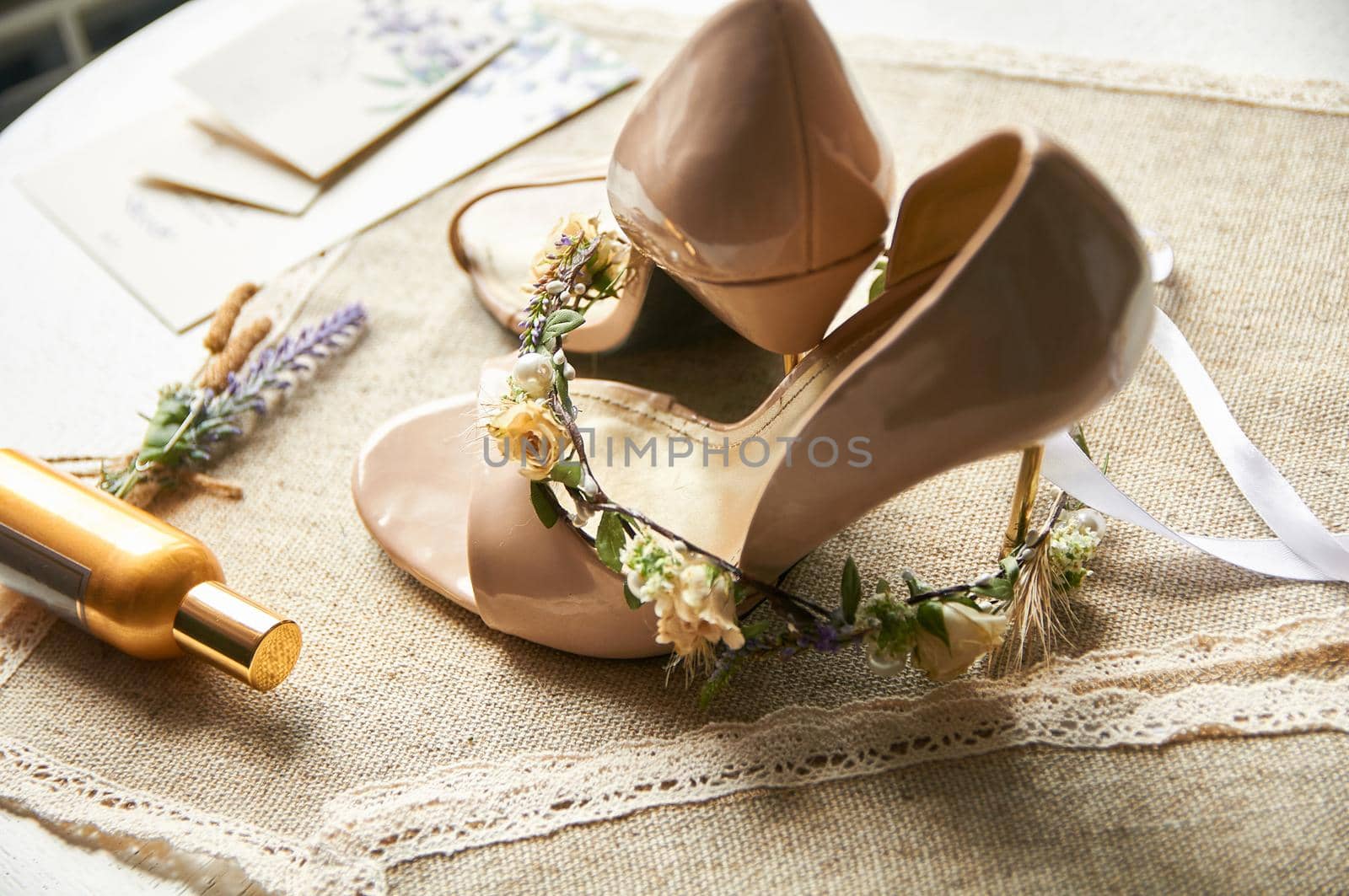 wedding shoes on a linen tablecloth table with a wreath of flowers for hair