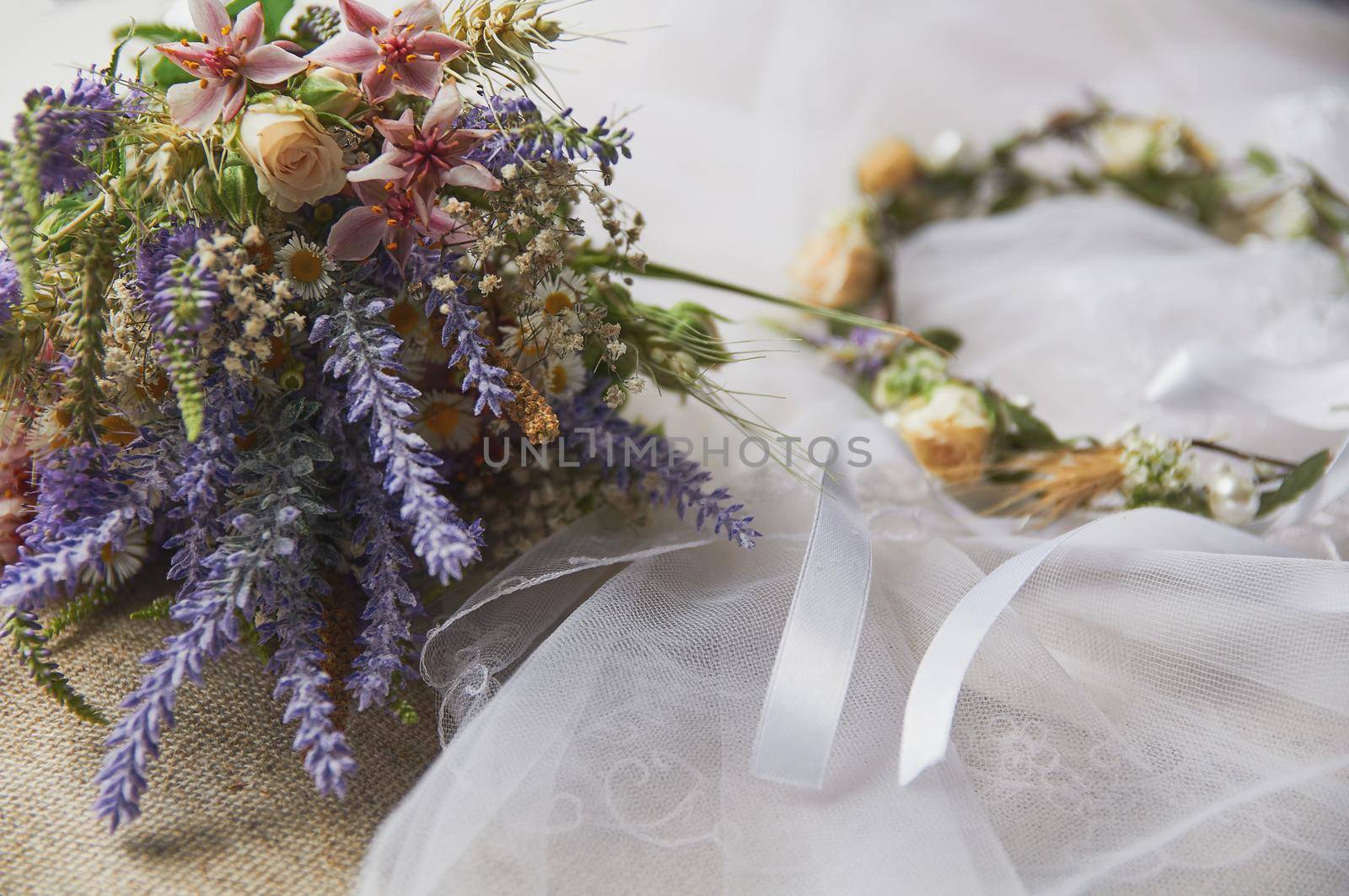 delicate wedding wreath in boho style on the table covered with a wedding veil