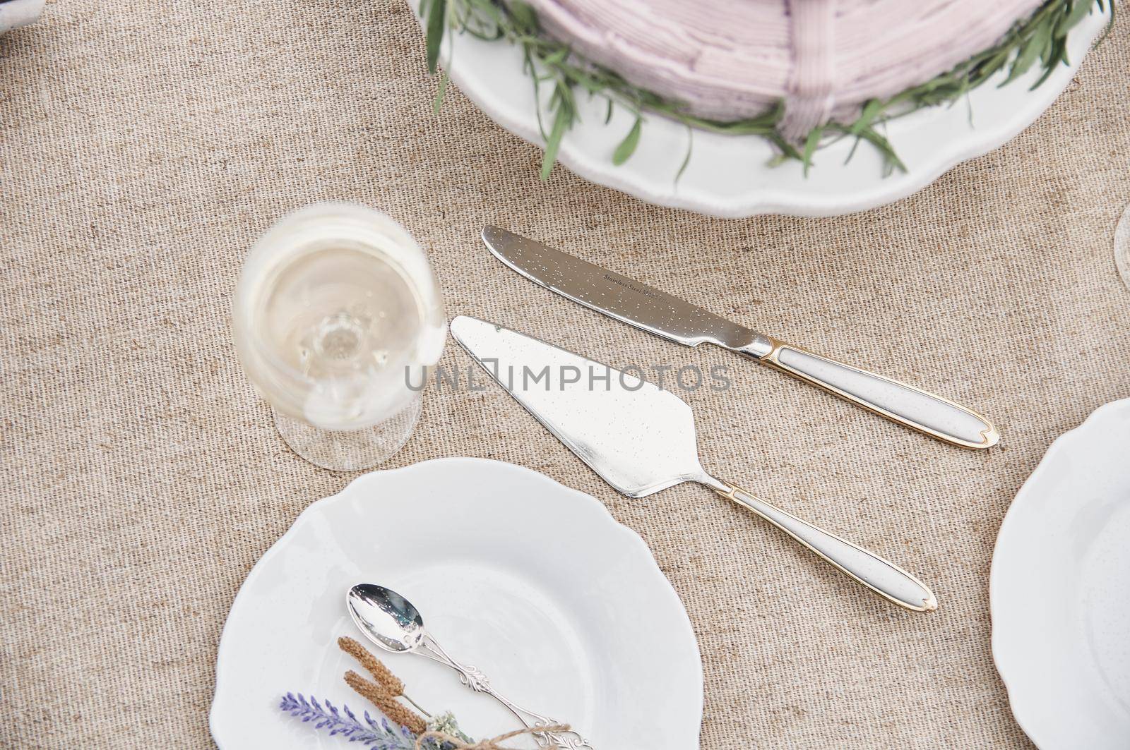 covered with a linen tablecloth, with plates, glasses, knife by ozornina