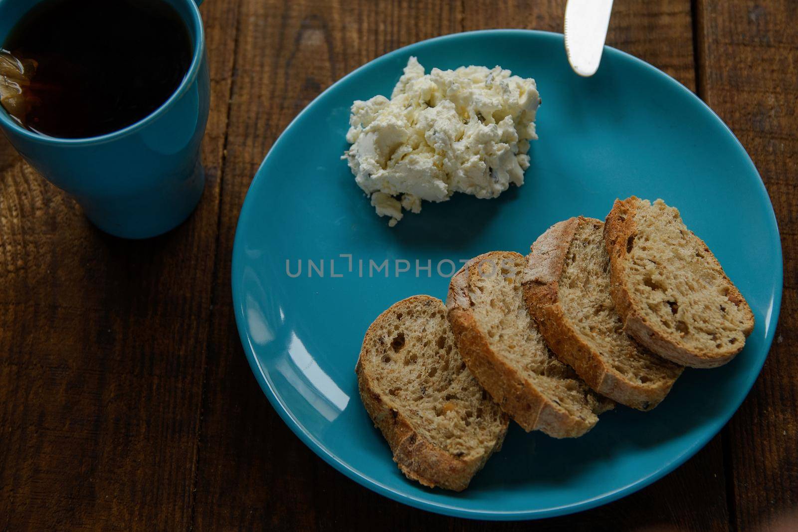 Breakfast bread toast on a blue plate with soft cheese by ozornina