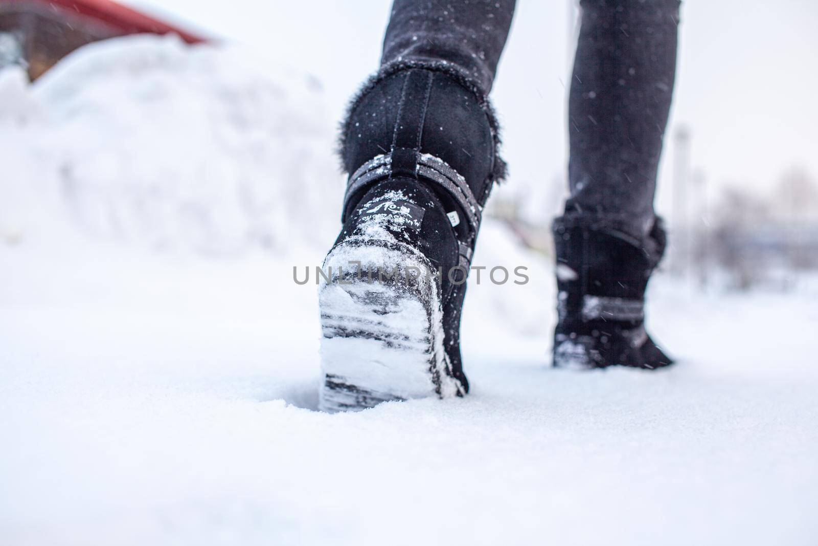 A person is walking on a slippery road, the first snow in the park by AnatoliiFoto