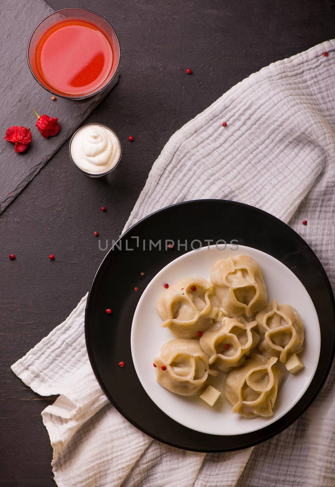 Manti or manty dumplings in a traditional bowl on wooden table