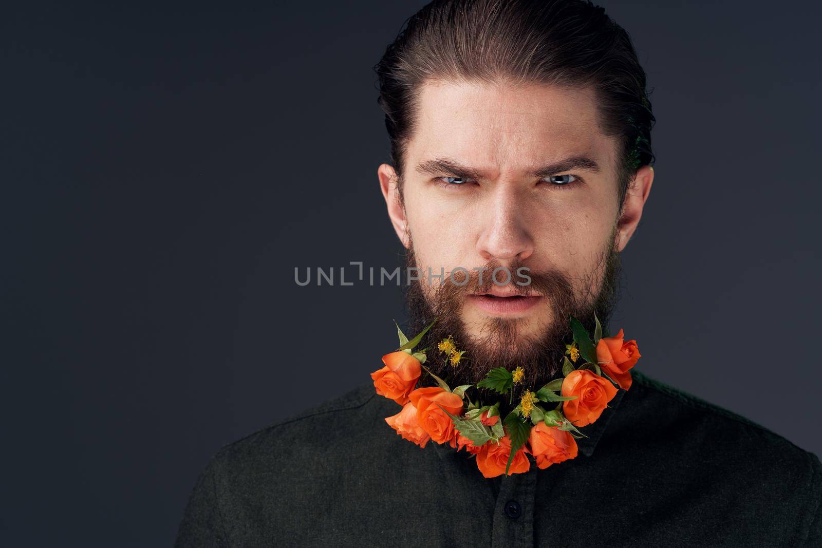 man flowers decoration in beard emotions black background. High quality photo