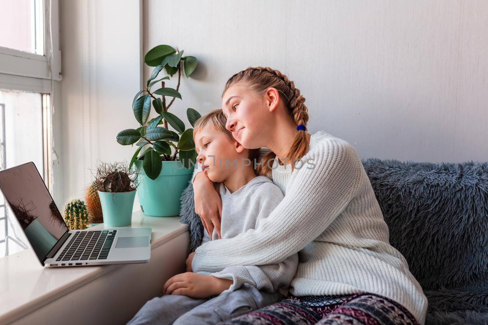 Cute kids having video call with grandparents on laptop during covid quarantine lockdown. Stay at home, distance communication concept