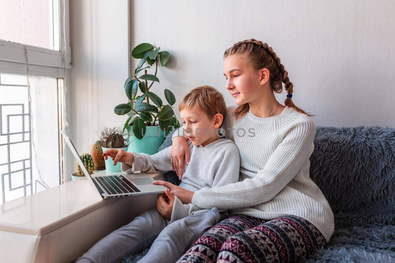 Cute kids having video call with grandparents on laptop during covid quarantine lockdown. by Len44ik