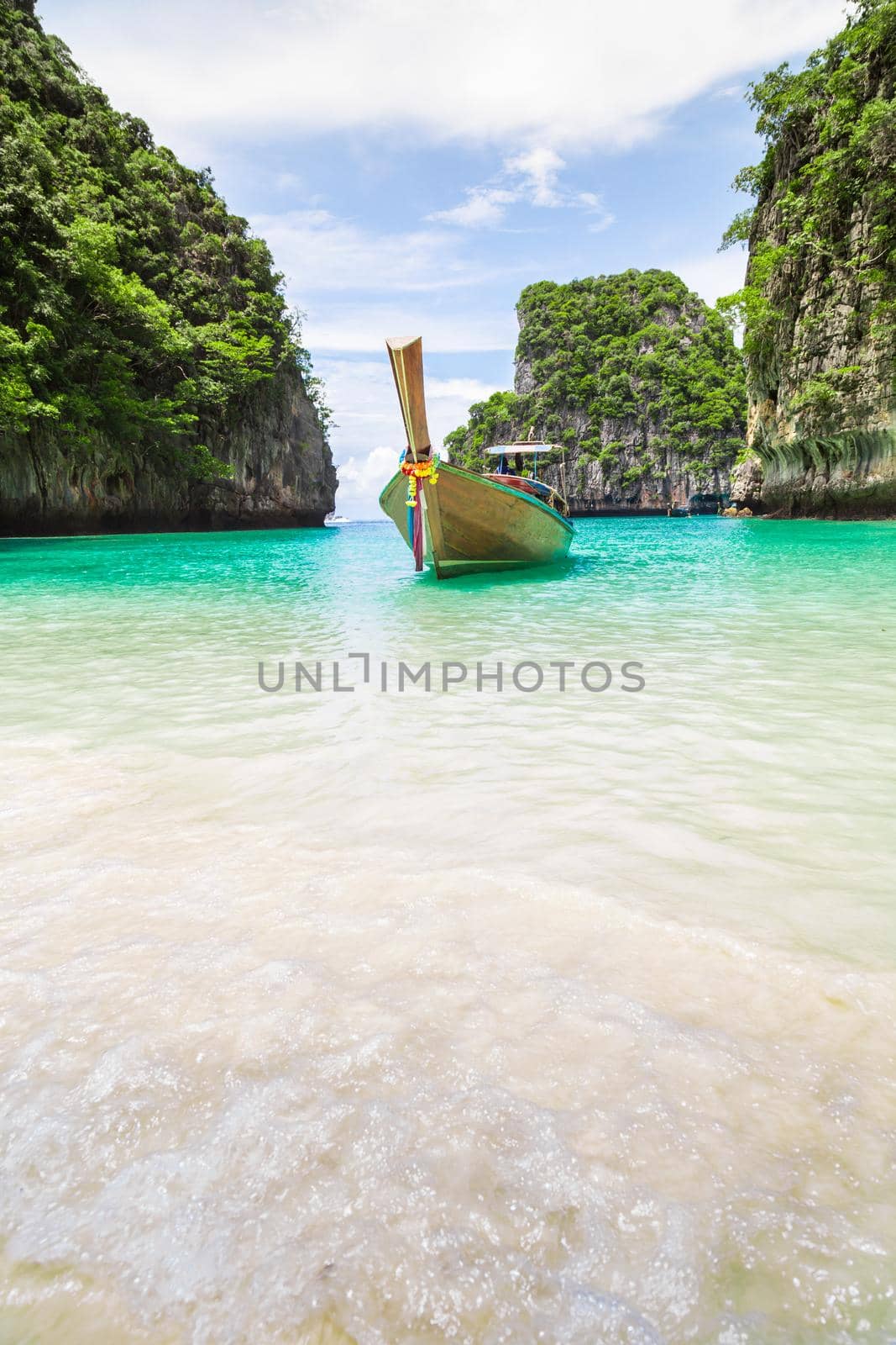 Thai traditional wooden longtail boat and beautiful beach in Thailand. by Gamjai