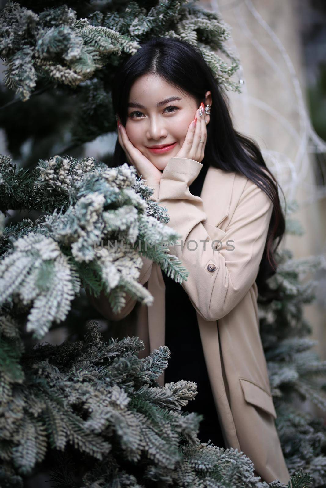 Portrait of young beautiful woman in winter clothes. while posing on snow background. Outdoor close-up photo of female model with romantic smile chilling in park in winter. by chuanchai