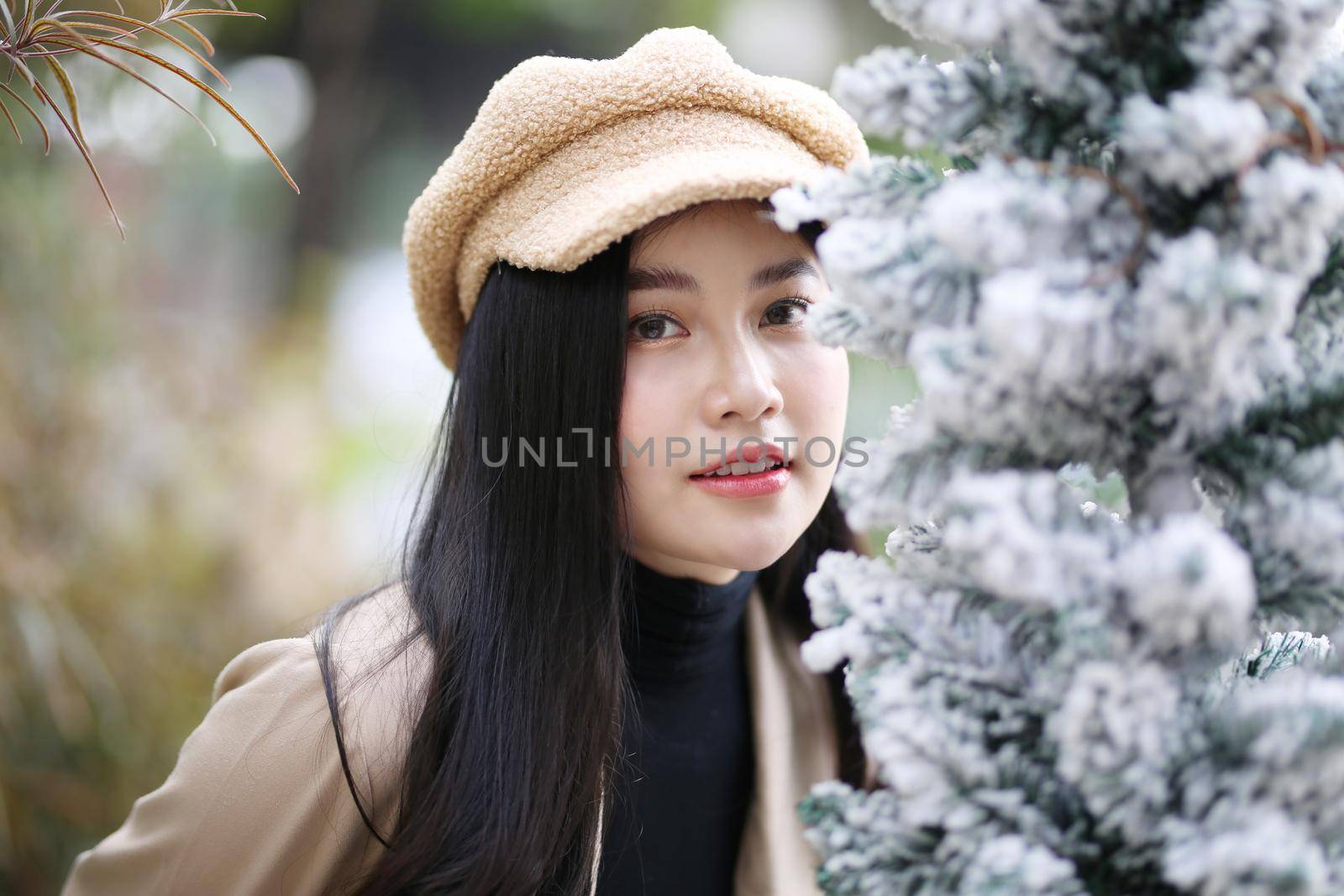 Portrait of young beautiful woman in winter clothes. while posing on snow background. Outdoor close-up photo of female model with romantic smile chilling in park in winter. by chuanchai