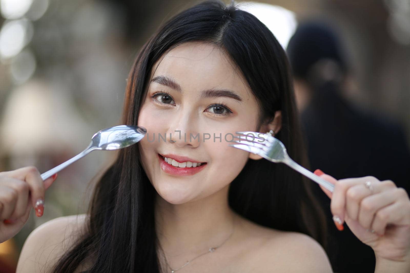 Beautiful young woman smiling while holding a glass of water at home. Lifestyle concept by chuanchai