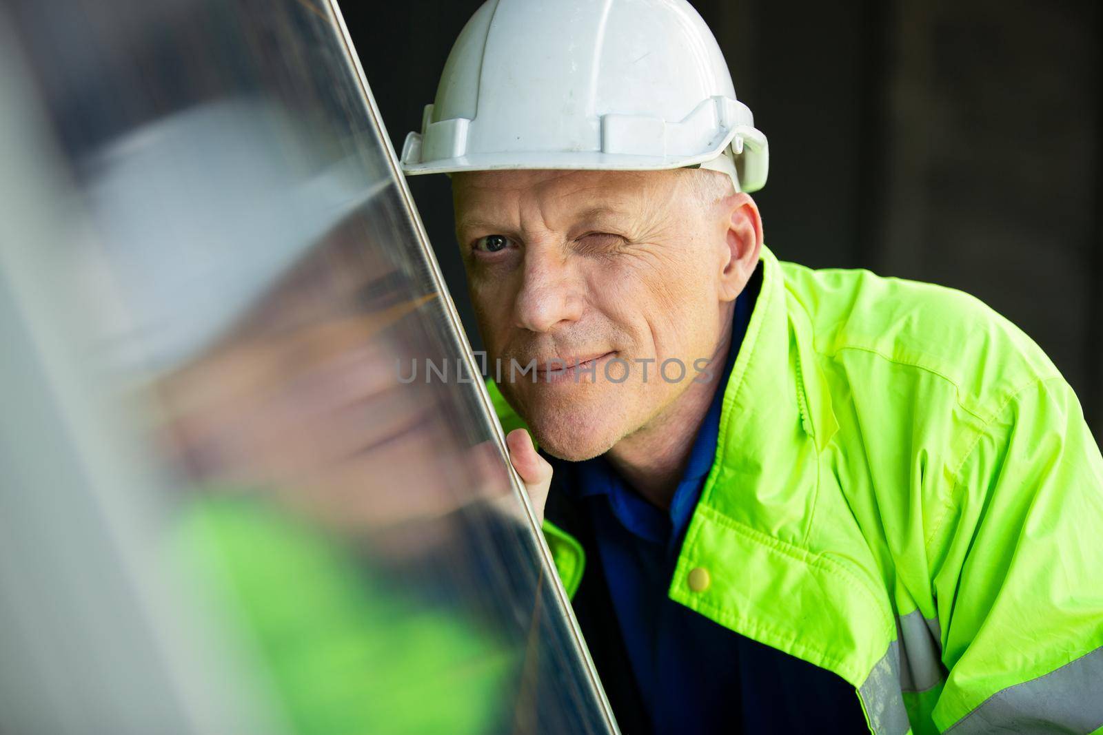 portrait of a engineer looking on solar cell panel.