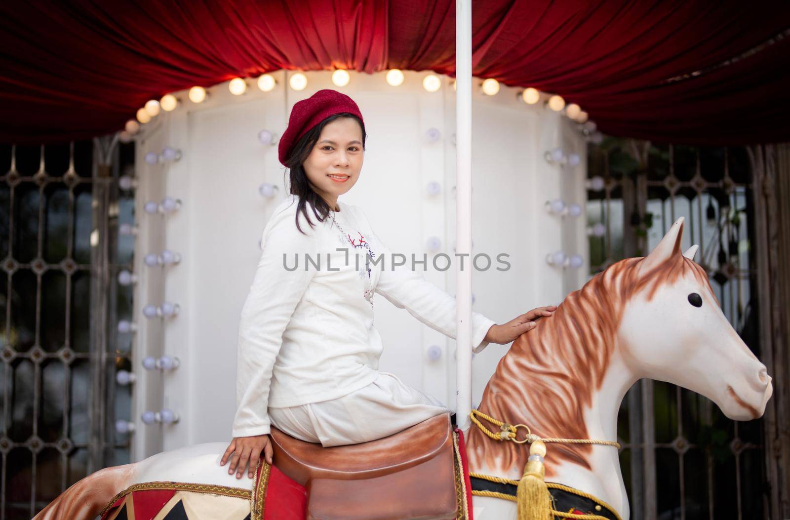 Young woman enjoying ride go around in the amusement park. by chuanchai