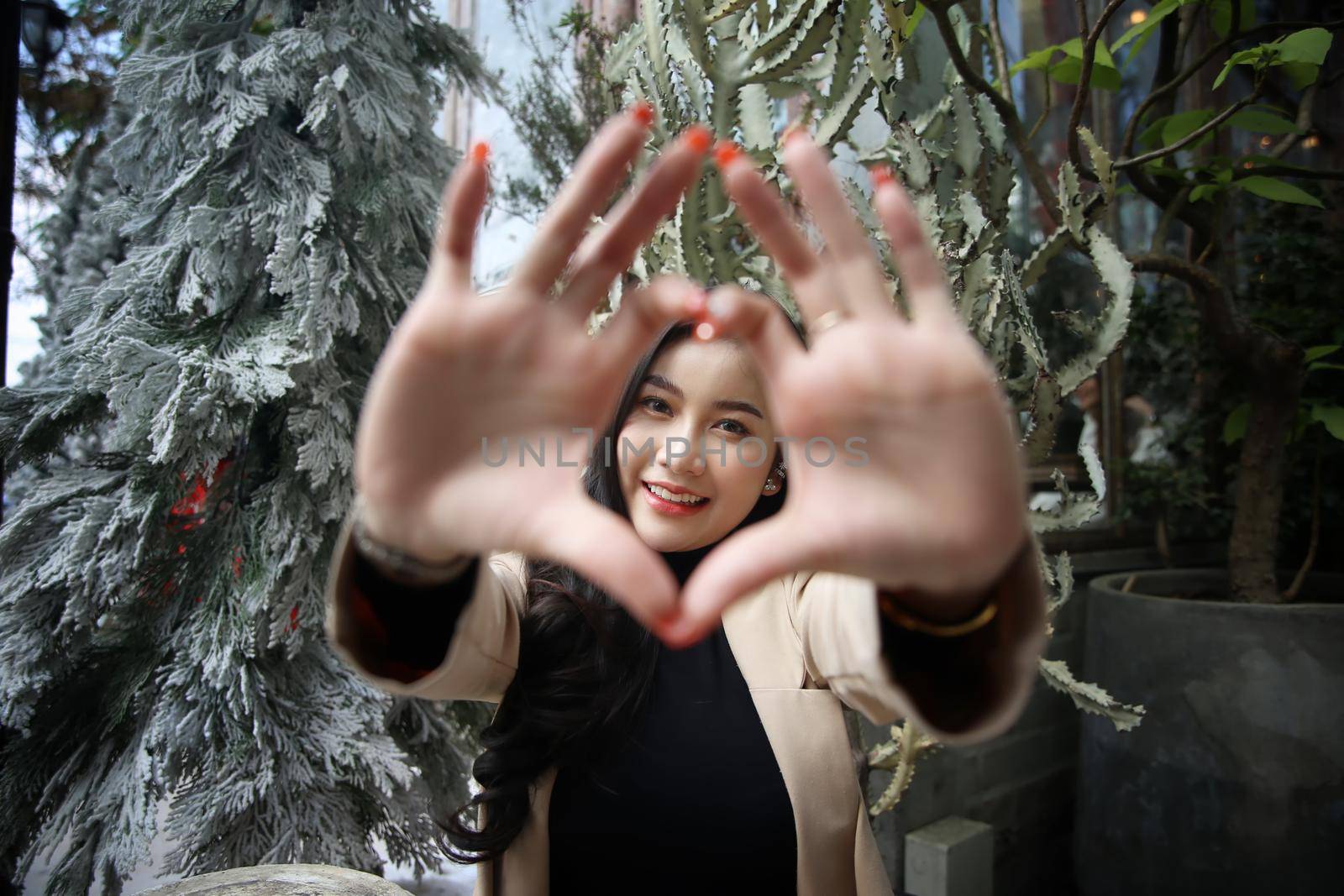 Portrait of young beautiful woman in winter clothes. while posing on snow background. Outdoor close-up photo of female model with romantic smile chilling in park in winter. by chuanchai