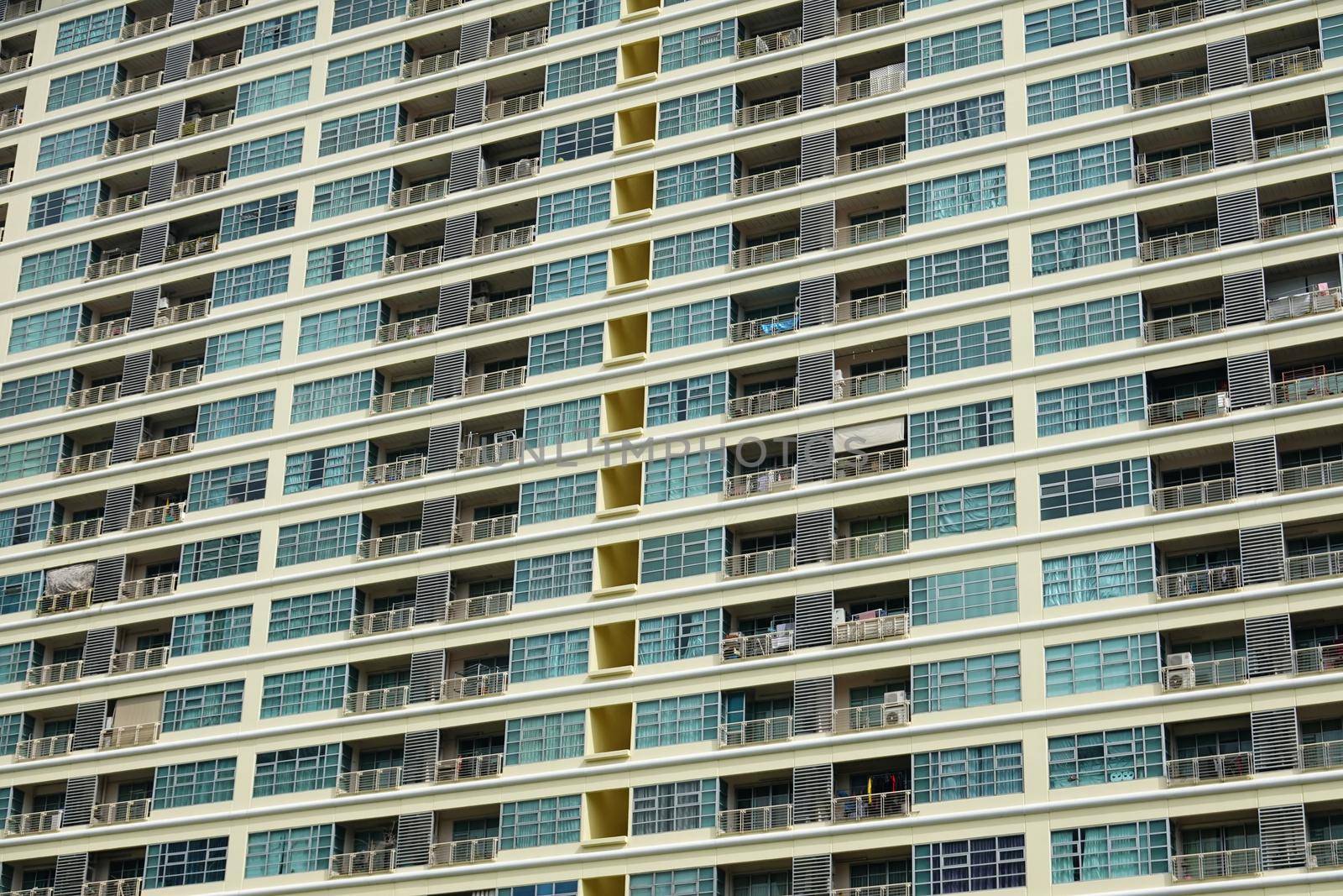 Low angle of apartment building with colorful painted facade and small balconies with metal railings on street