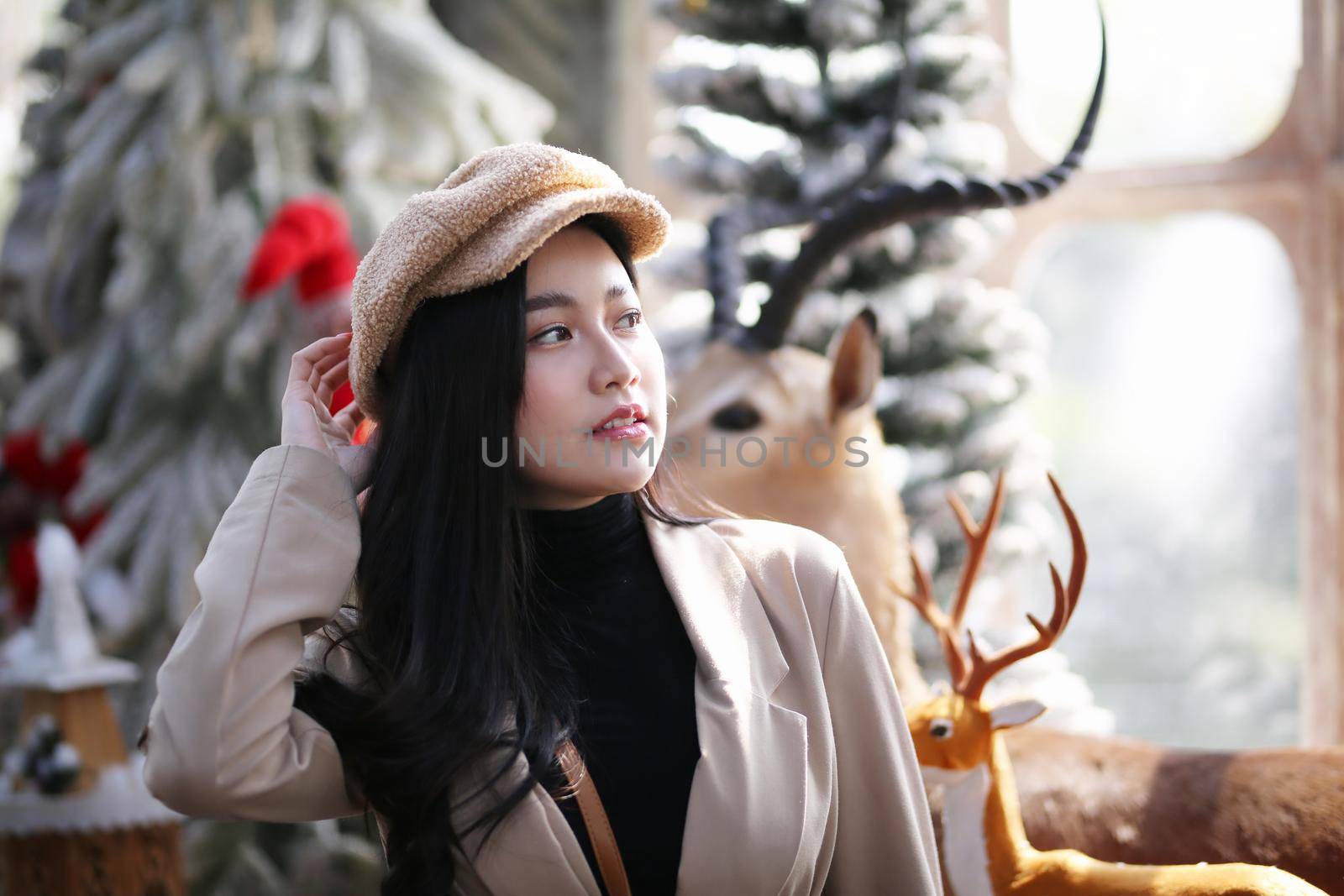 Portrait of young beautiful woman in winter clothes. while posing on snow background. Outdoor close-up photo of female model with romantic smile chilling in park in winter. by chuanchai