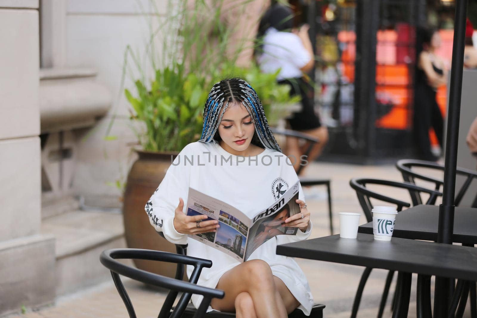 Happy stylish young hipster woman with long blue hair pink jacket, hat on the street in urban city. by chuanchai