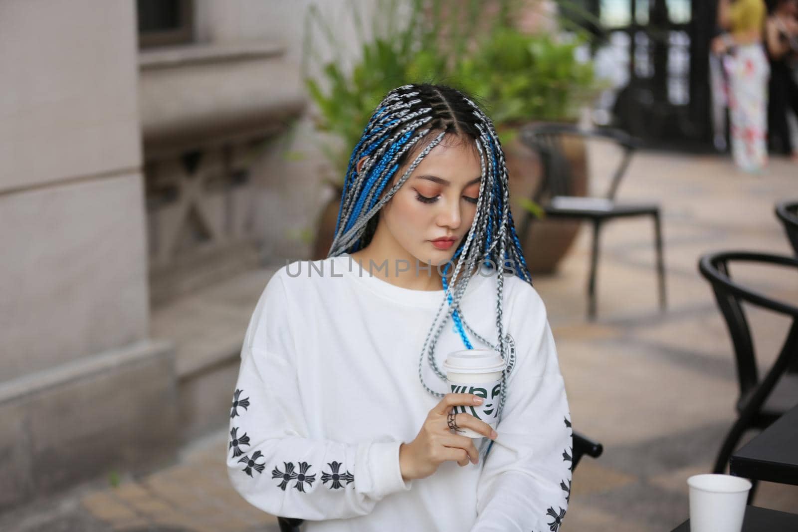 Happy stylish young hipster woman with long blue hair pink jacket, hat on the street in urban city. by chuanchai