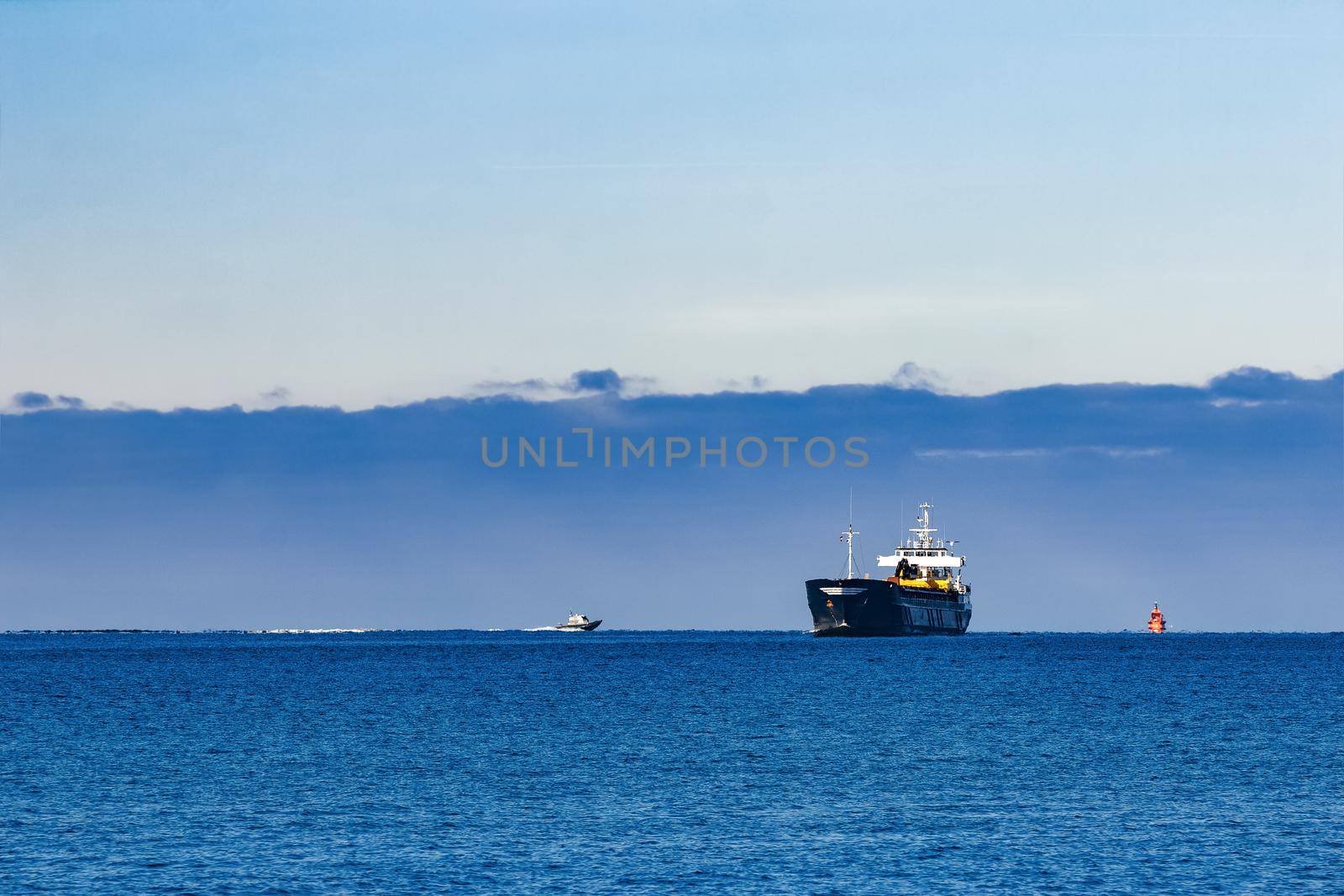 Black Sailing Bulk Carrier. Cargo Ship with Long Reach Excavator Moving in Still Water at Sunny Day by the Sea