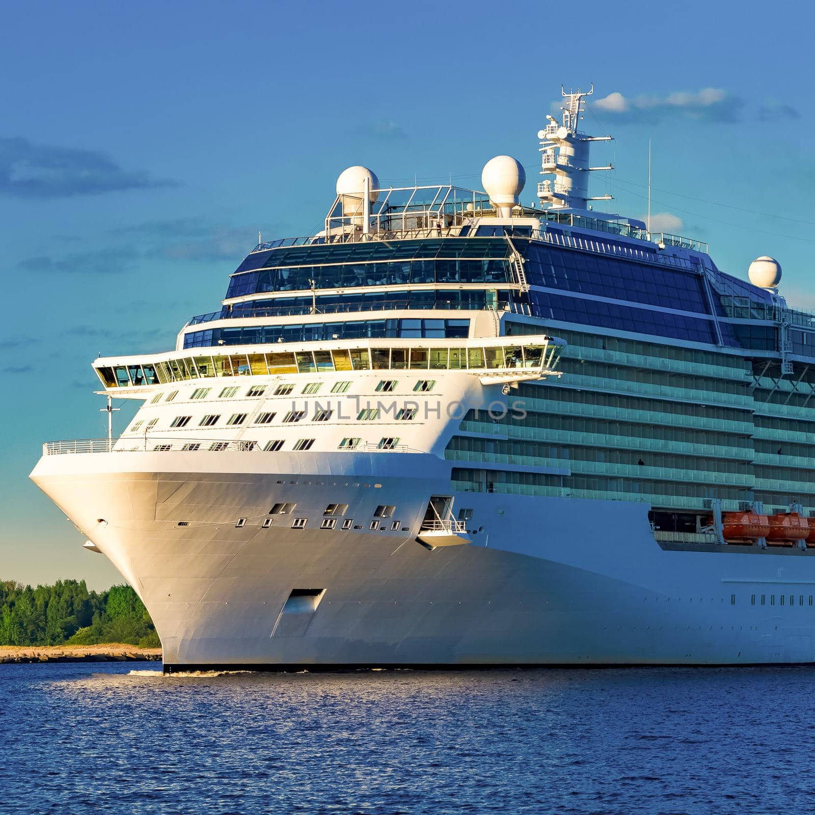 White giant brand new passenger ship moving in clear summer day