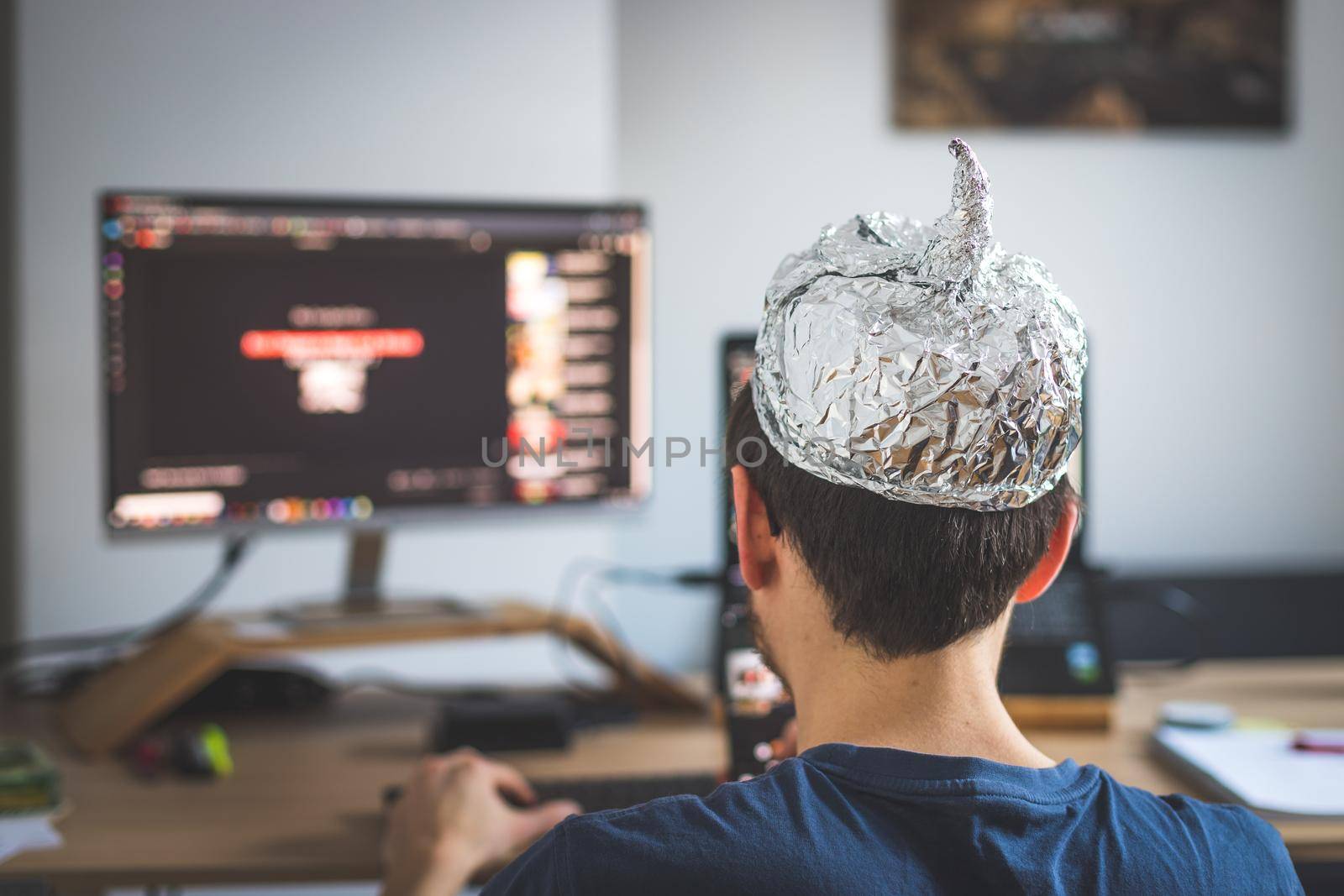 Young man is wearing aluminum cap, conspiracy theory concept