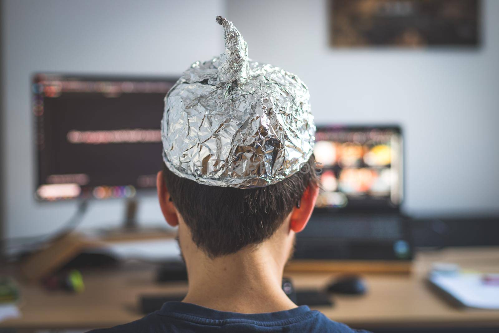 Young man is wearing aluminum cap, conspiracy theory concept