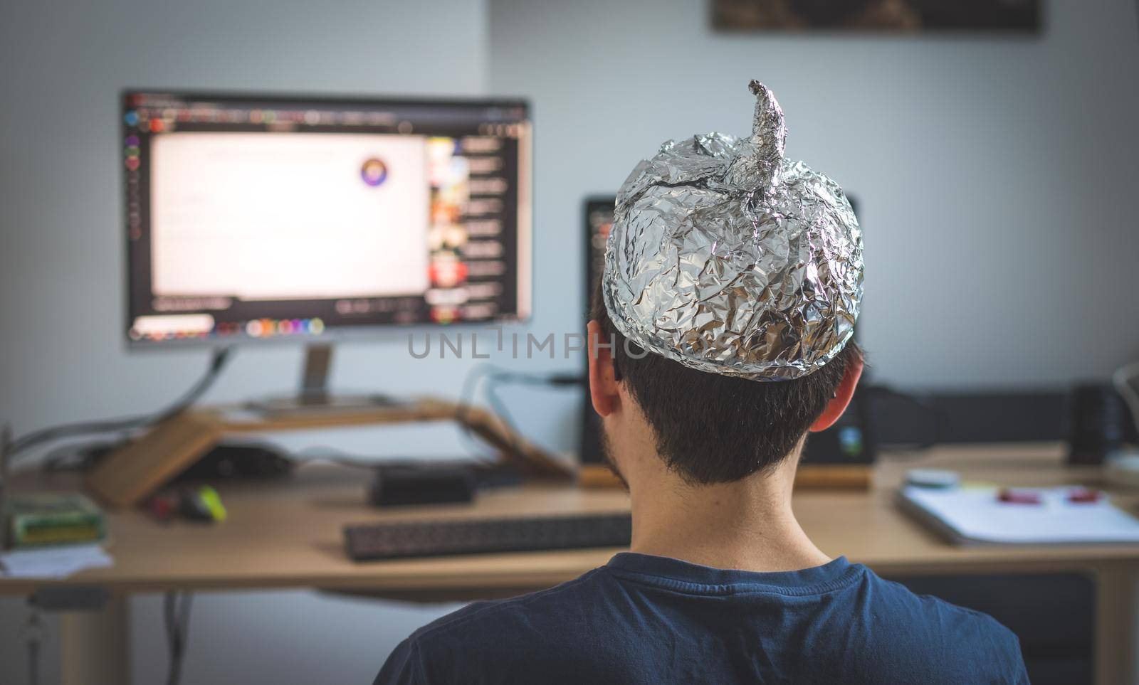 Young man is wearing aluminum cap, conspiracy theory concept