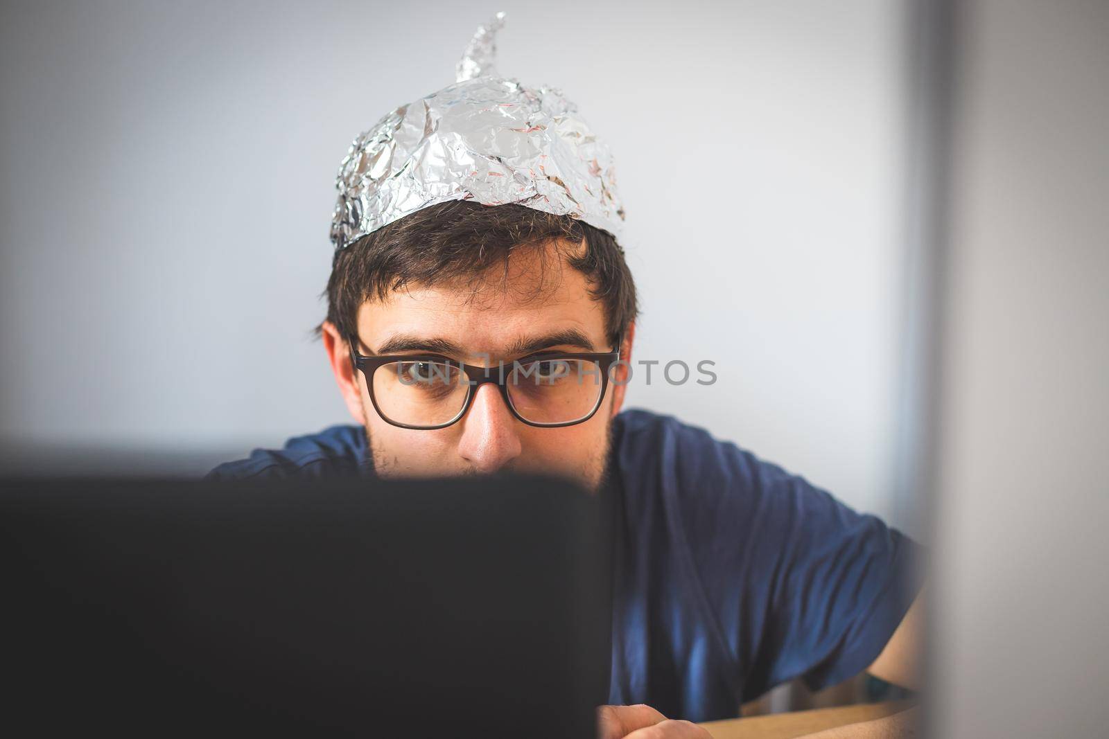 Young man is wearing aluminum cap, conspiracy theory concept