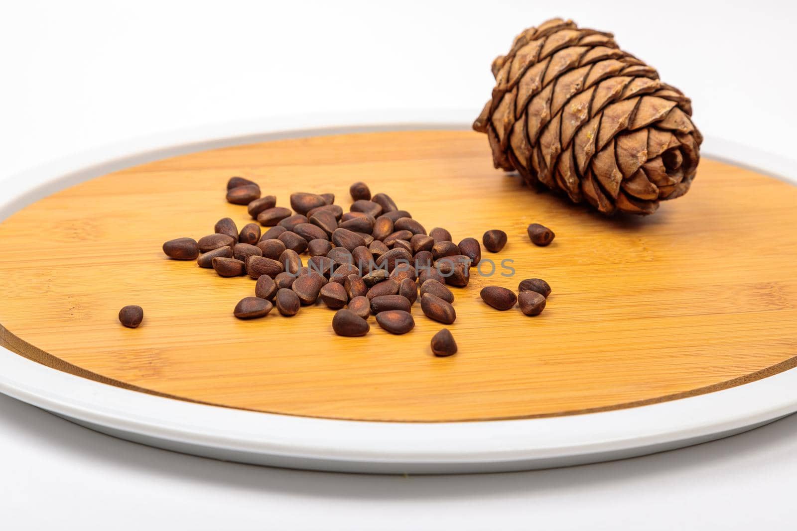 The fruit of Siberian cones - pine nuts on a kitchen cutting board, is a delicious, nutritious and healthy product.