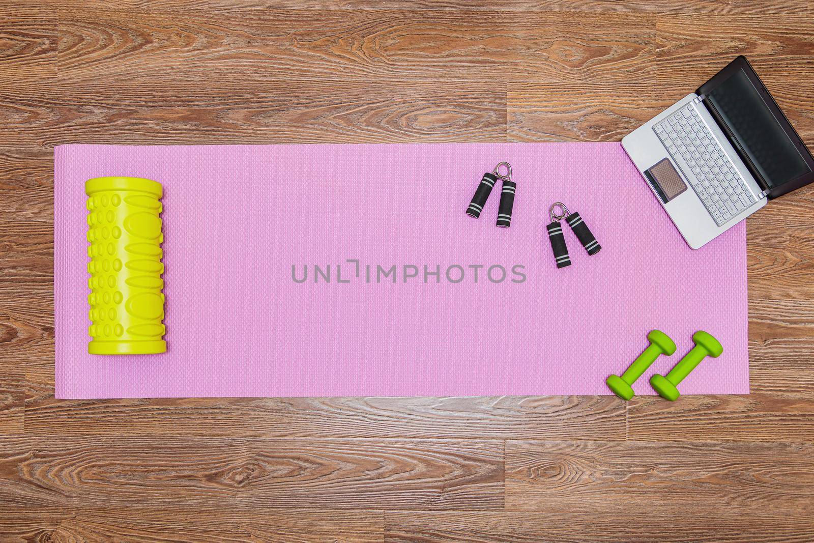 Fitness mat, dumbbells, expander and laptop for online workouts at home. by Yurich32