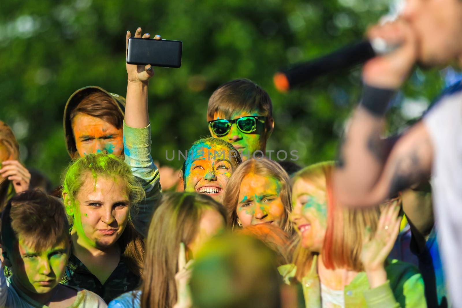 Russia, Moscow - June 25, 2017. Portrait of a girl with bright flowers on her face. Laughs with happiness. Holi is a traditional holiday in India