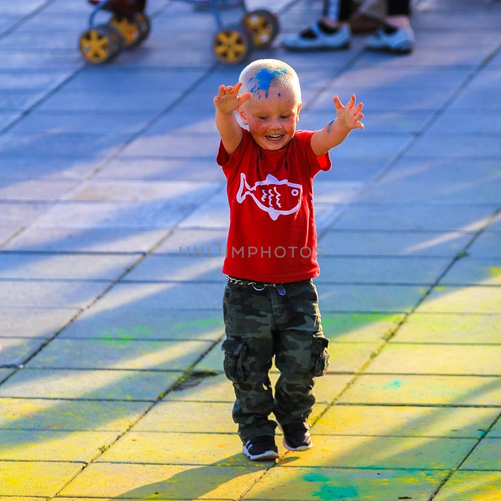 Russia, Moscow - June 25, 2017. Little boy with bright colors on his face. Laughs with happiness. Holi is a traditional holiday in India