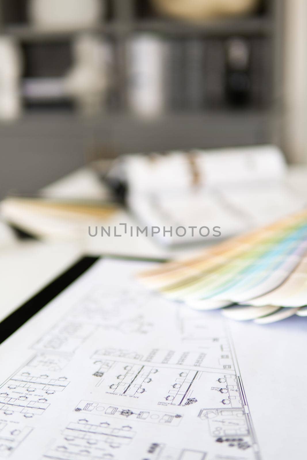 Interior designer's working table, an architectural plan of the house, a color palette, furniture and fabric samples. Drawings and plans for house decoration.