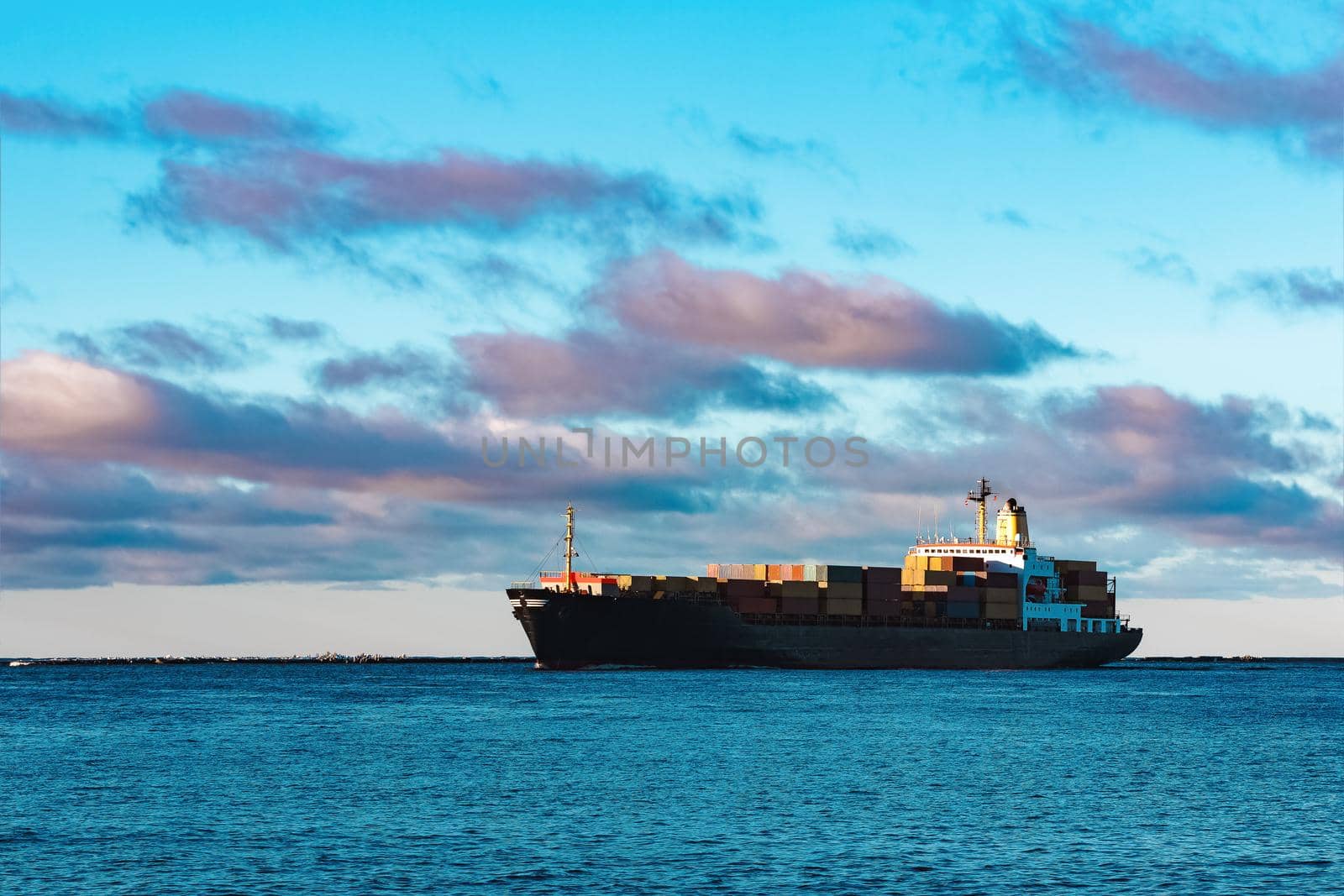 Modern black container ship moving from Baltic sea