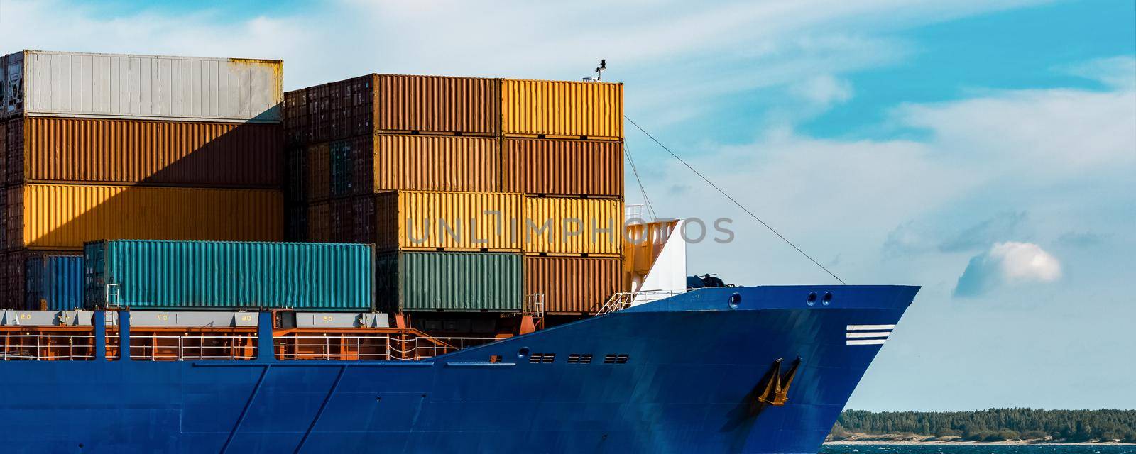 Blue container ship in travel. Logistics and freight industry