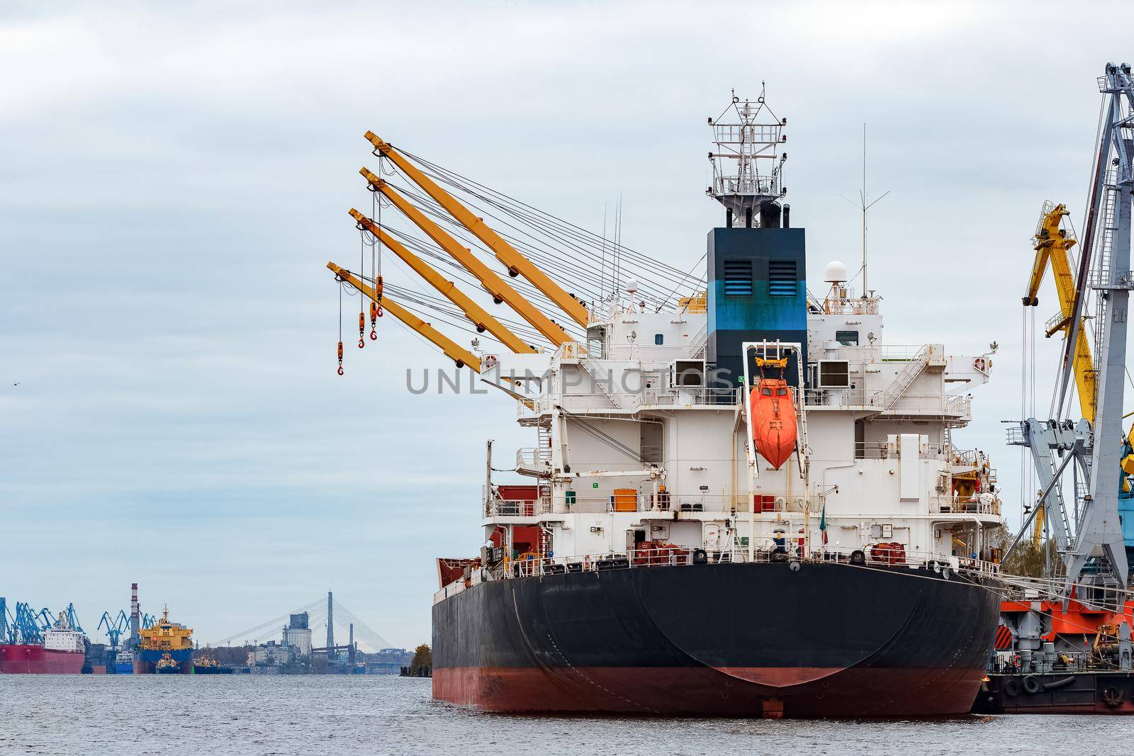 Black cargo ship loading in the port of Riga, Europe