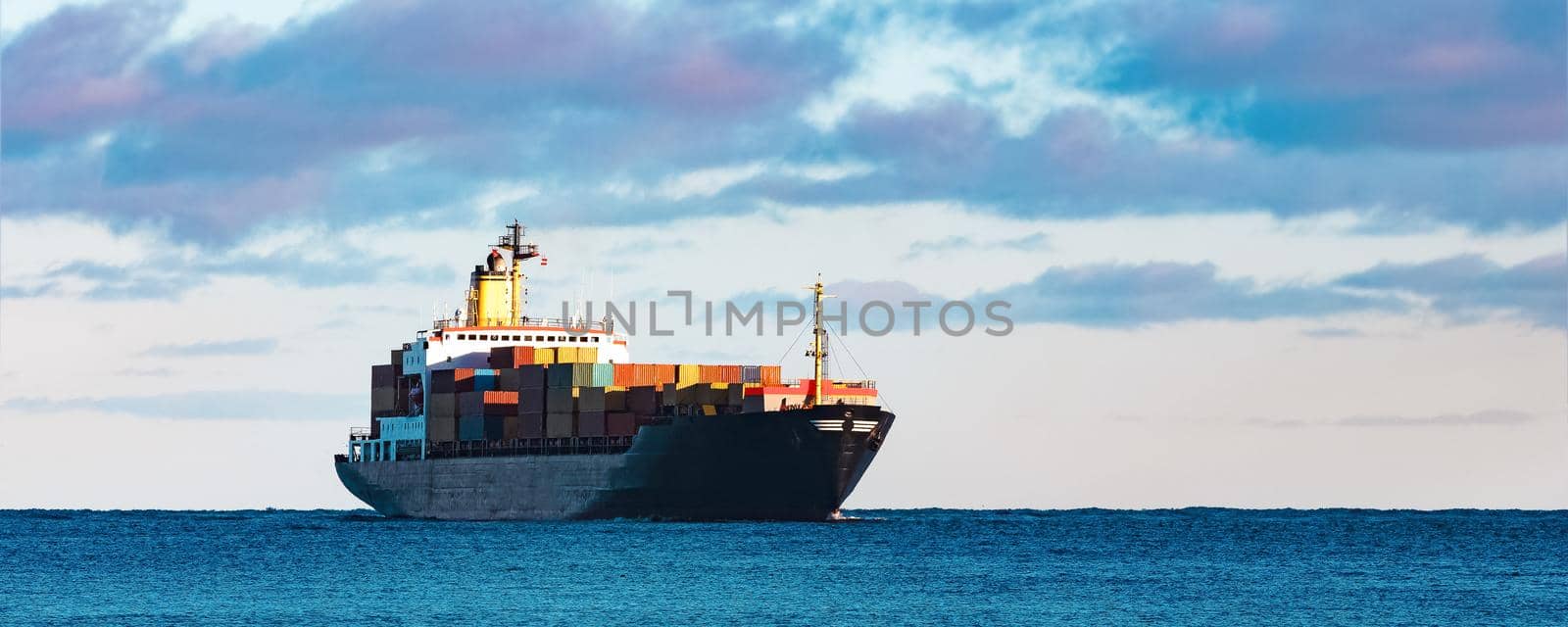Modern black container ship moving from Baltic sea