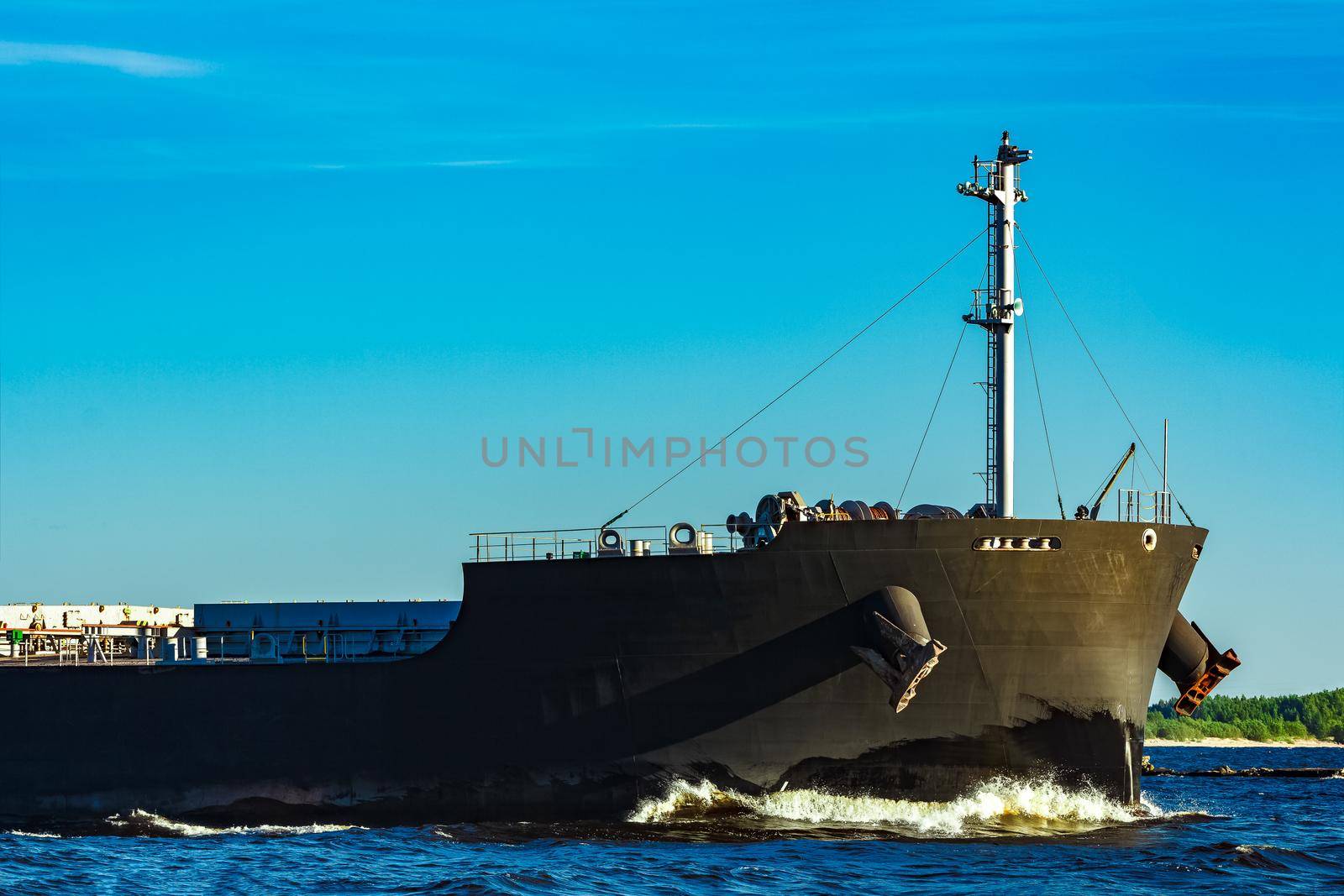 Black cargo ship moving to Baltic sea at clear day