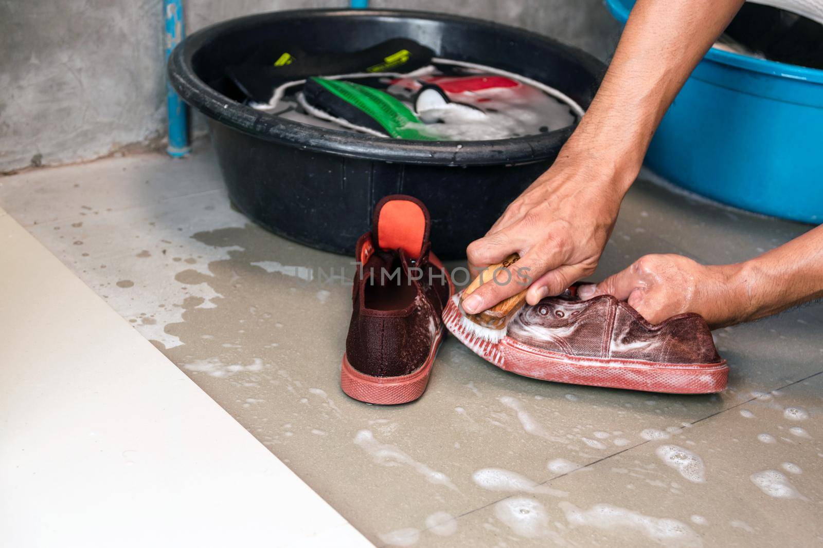 Washing the sneakers with a washing brush and washing powder.