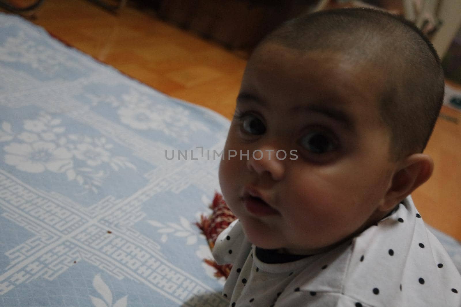 Baby girl with lovely face, big eyes and cute face gesture. Toddler baby making sweet activities