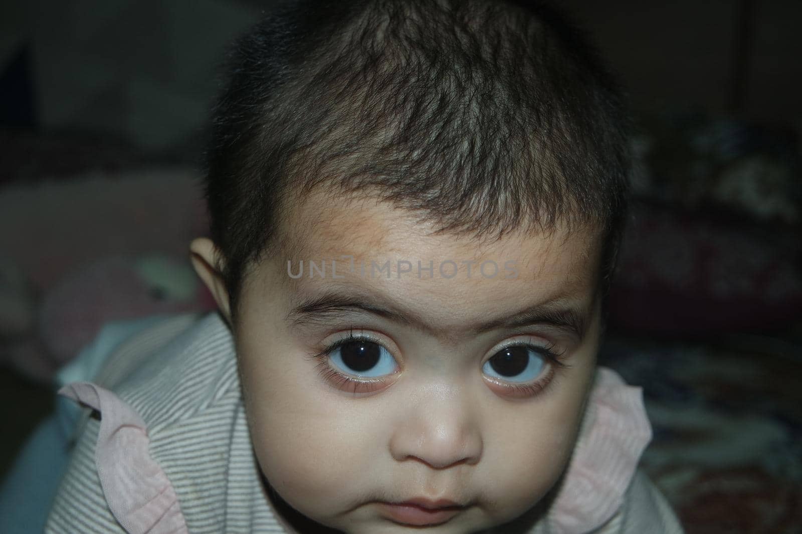 Baby girl with lovely face, big eyes and cute face gesture. Toddler baby making sweet activities