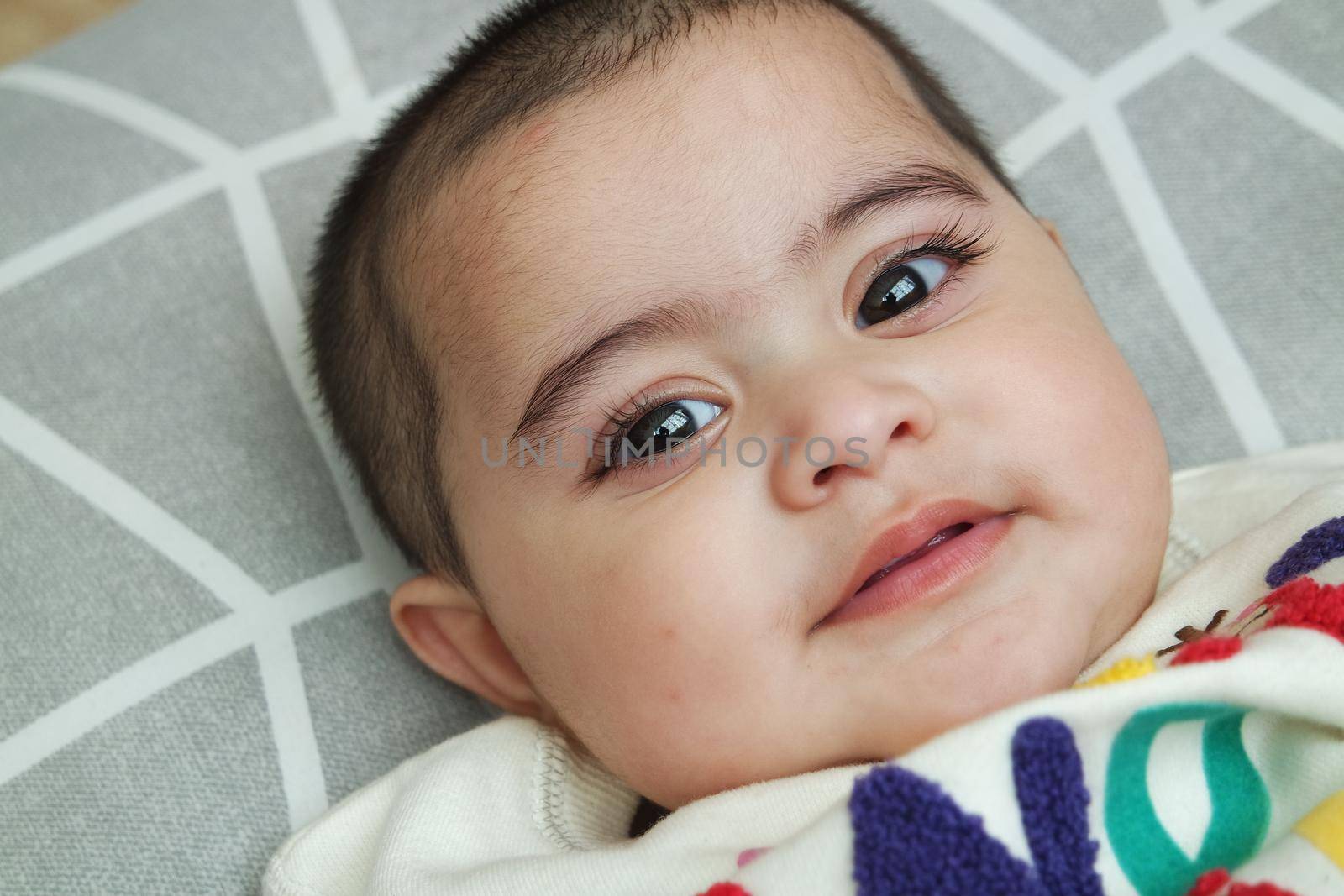 Baby girl with lovely face, big eyes and cute face gesture. Toddler baby making sweet activities