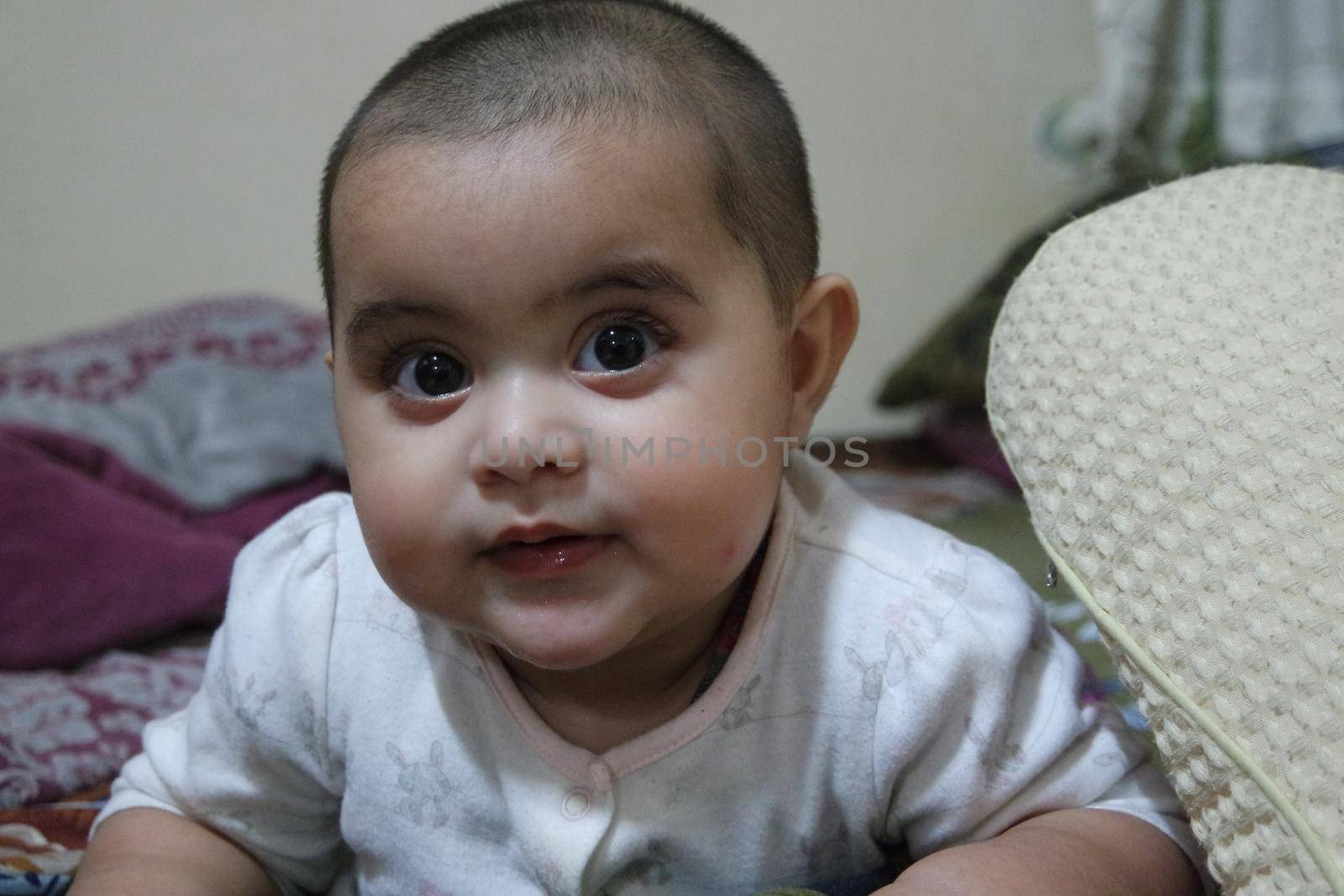 Baby girl with lovely face, big eyes and cute face gesture. Toddler baby making sweet activities