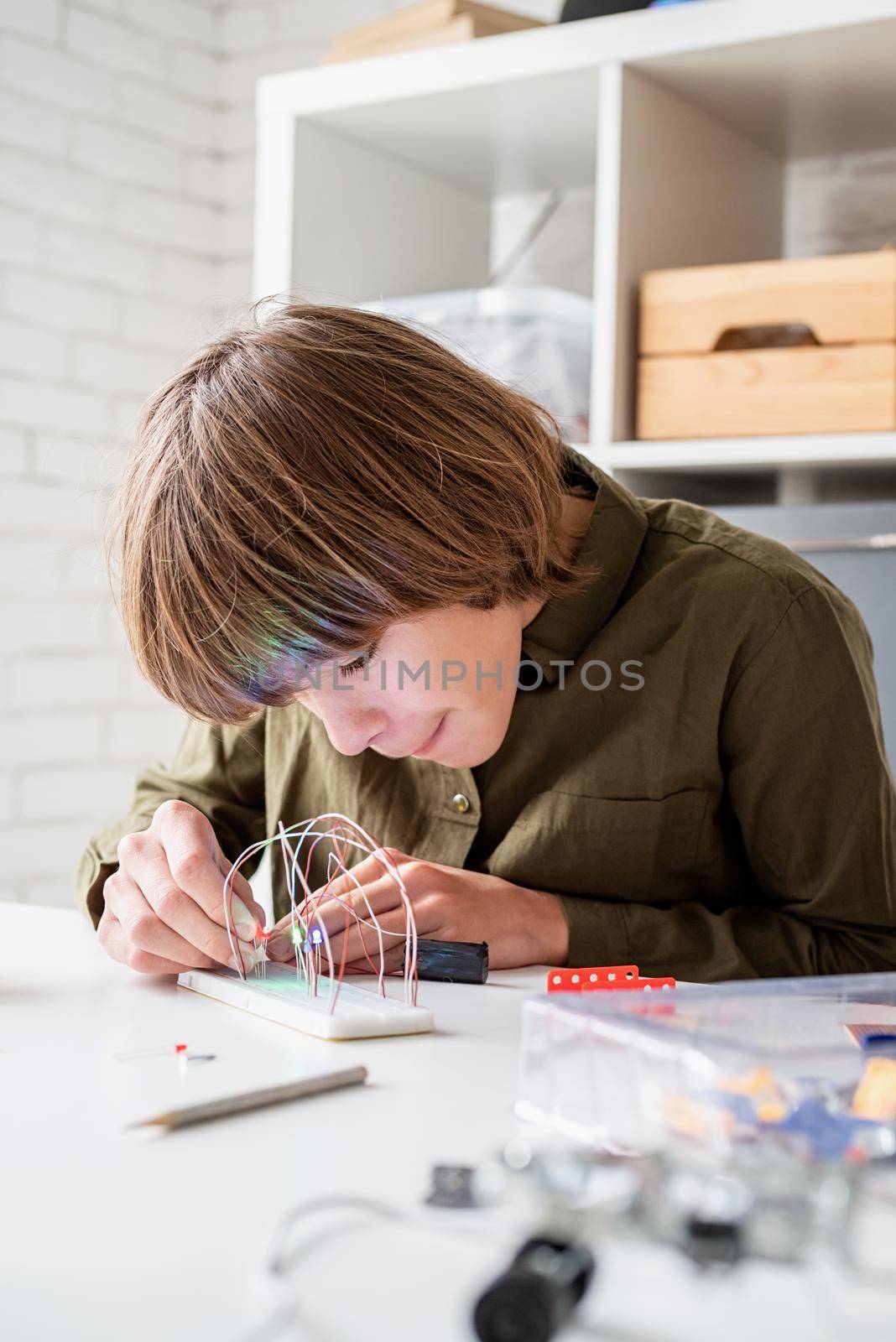 Nice boy constructing a robot car playing with lights by Desperada