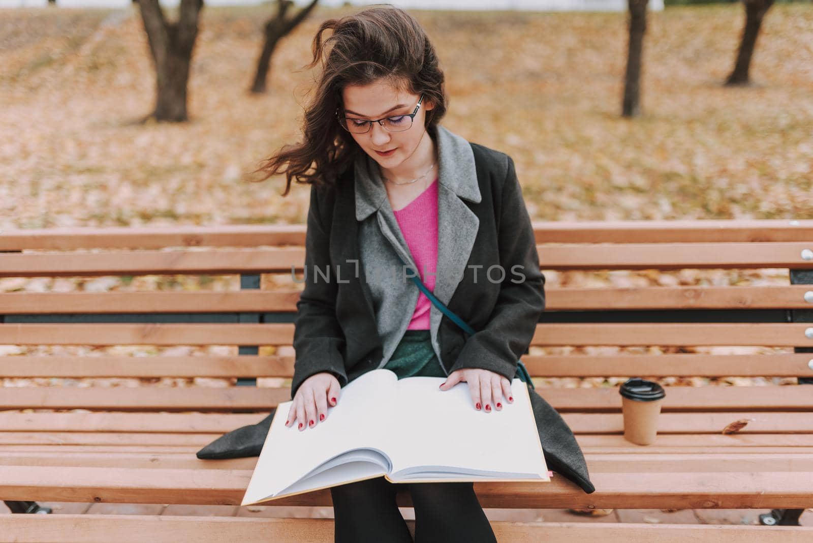 Calm student on windy day studying in the park by monakoartstudio