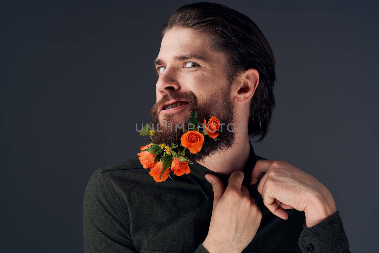 Bearded cheerful man flowers different romance decoration black background. High quality photo