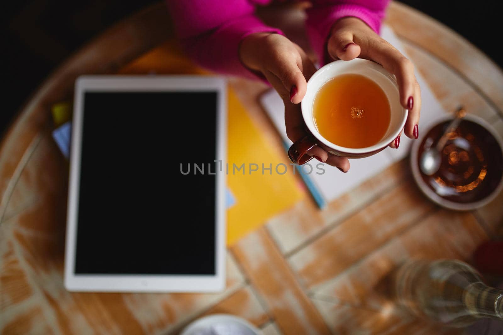Woman sitting at the table with tea by monakoartstudio